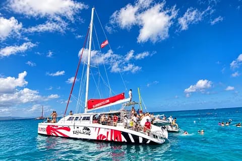 Catamarã com pessoas a bordo no mar azul